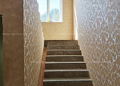 Выполнена оклейка стен обоями на лестнице